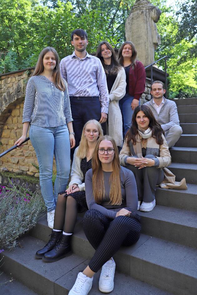 mehrere Azubis sitzen auf einer Treppe