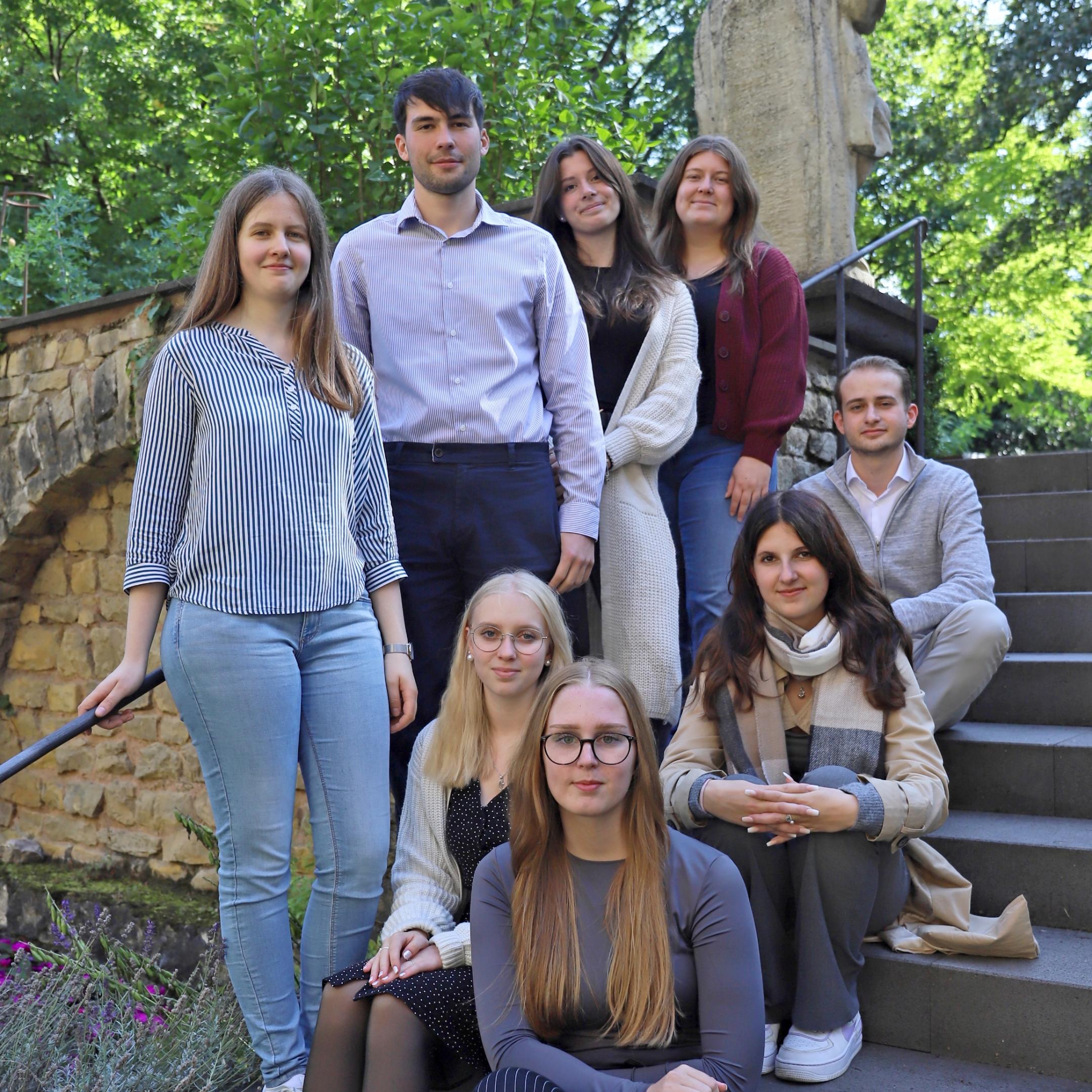 mehrere Azubis sitzen auf einer Treppe
