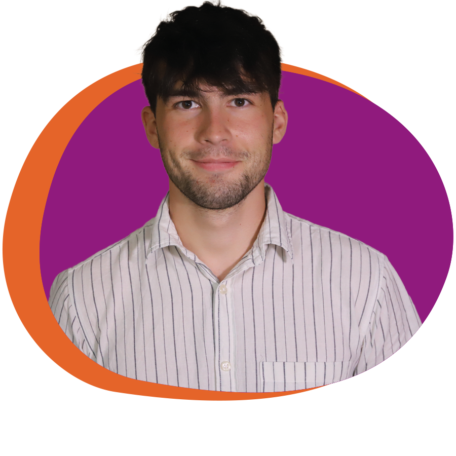 Junger Mann mit Hemd und dunklen kurzen Haaren schaut freundlich in die Kamera.