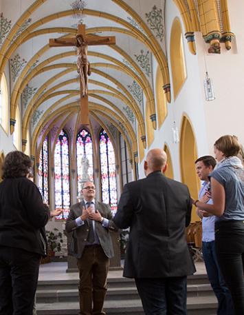 mehrere Menschen in einem Kreis versammelt in einer Kirche