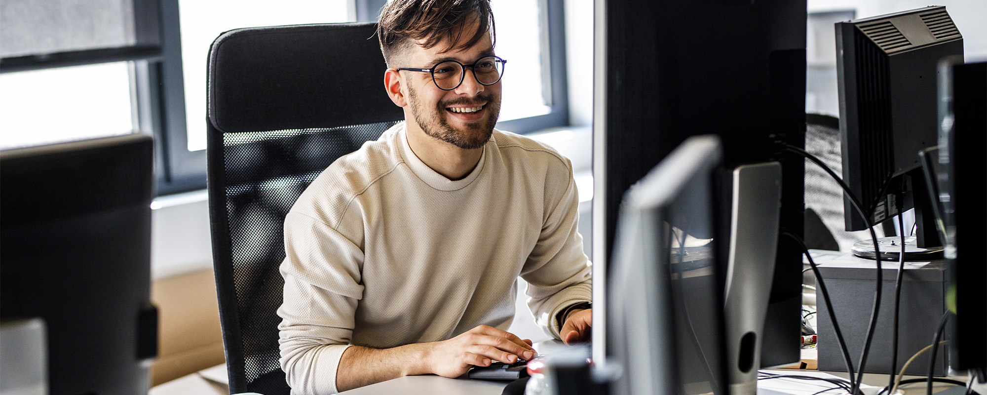 ein junger Mann arbeitet an einem Bildschirm