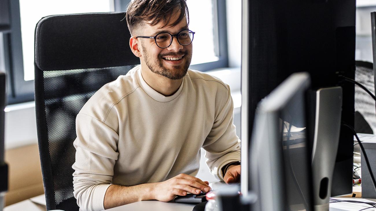 ein junger Mann arbeitet an einem Bildschirm