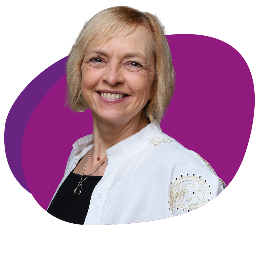 Freundlich lachende Frau mit kinnlangem, blondem Haar schaut in die Kamera.