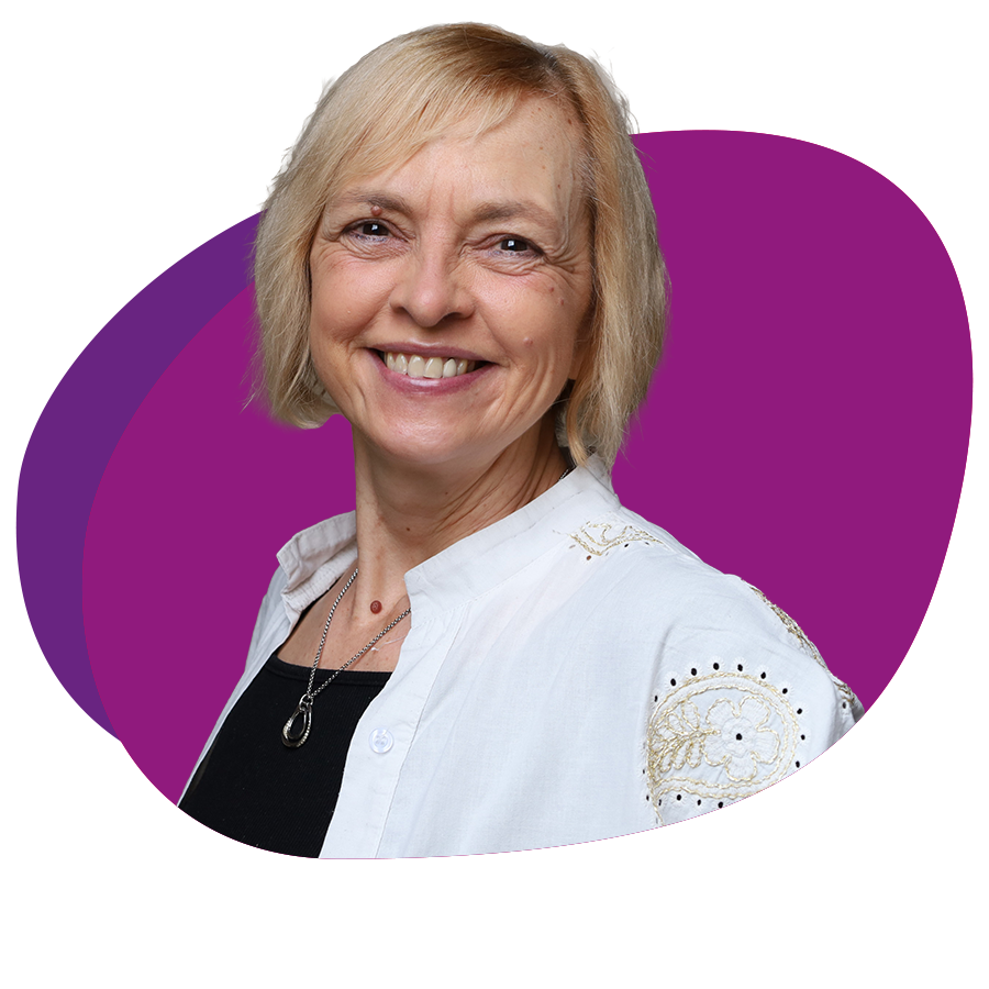 Freundlich lachende Frau mit kinnlangem, blondem Haar schaut in die Kamera.