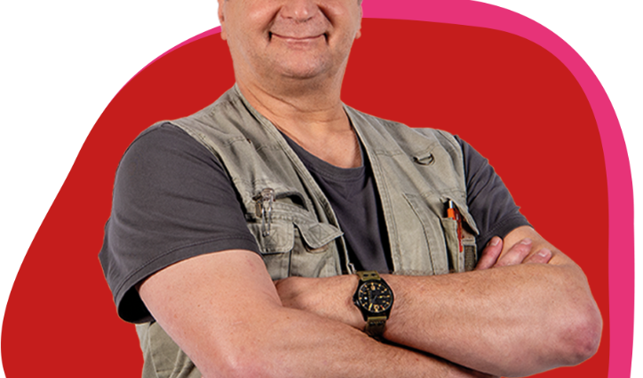 Älterer Herr verschränkt freundlich die Arme vor der Brust und lächelt in die Kamera.