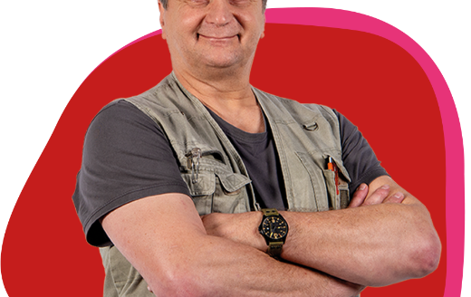 Älterer Herr verschränkt freundlich die Arme vor der Brust und lächelt in die Kamera.