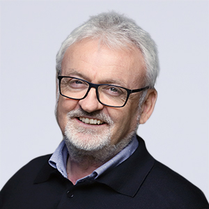 Ein Herr mit Brille lächelt in die Kamera.
